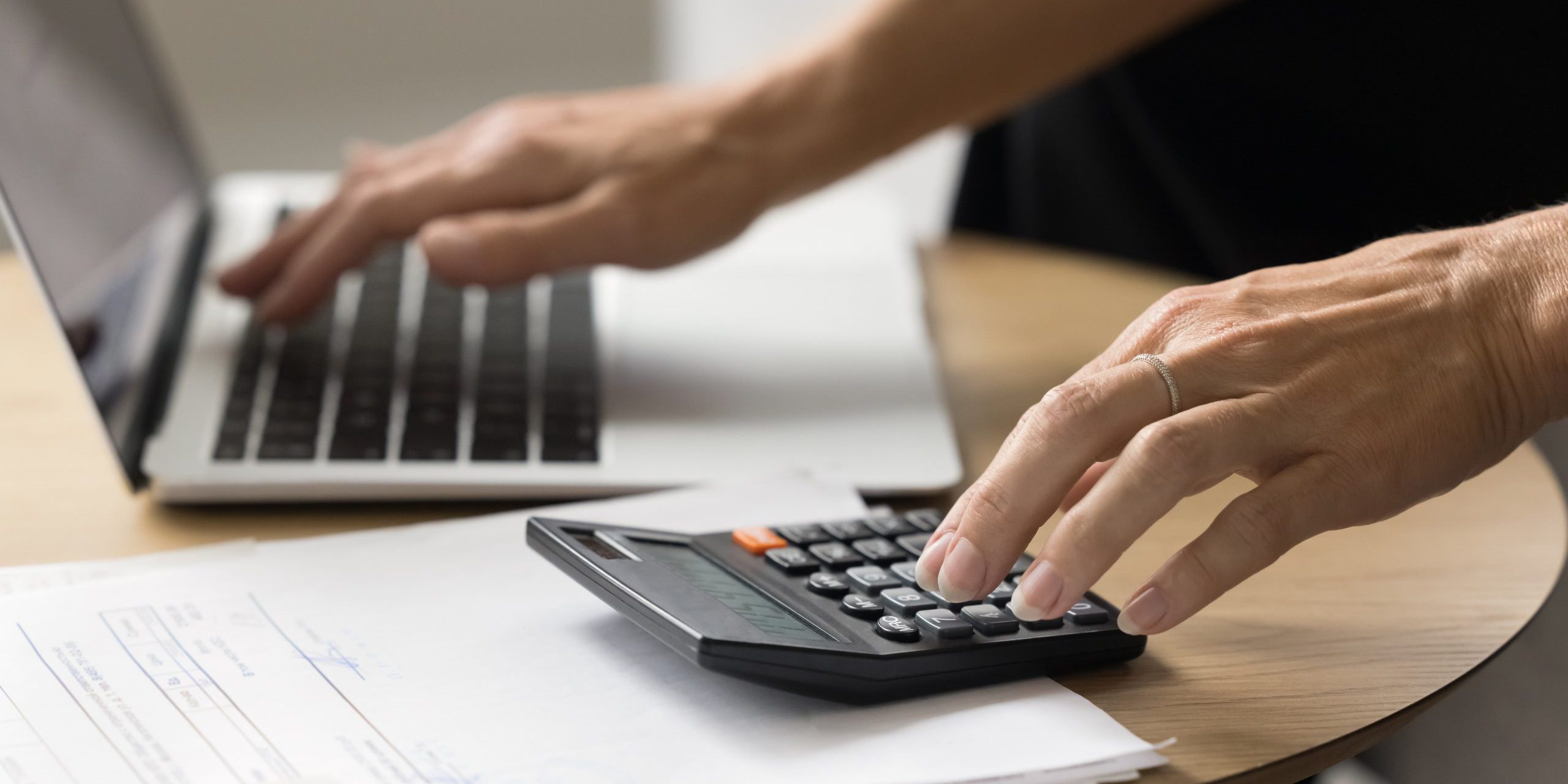 Hands,Of,Senior,Elder,Woman,Using,Laptop,And,Calculator,For